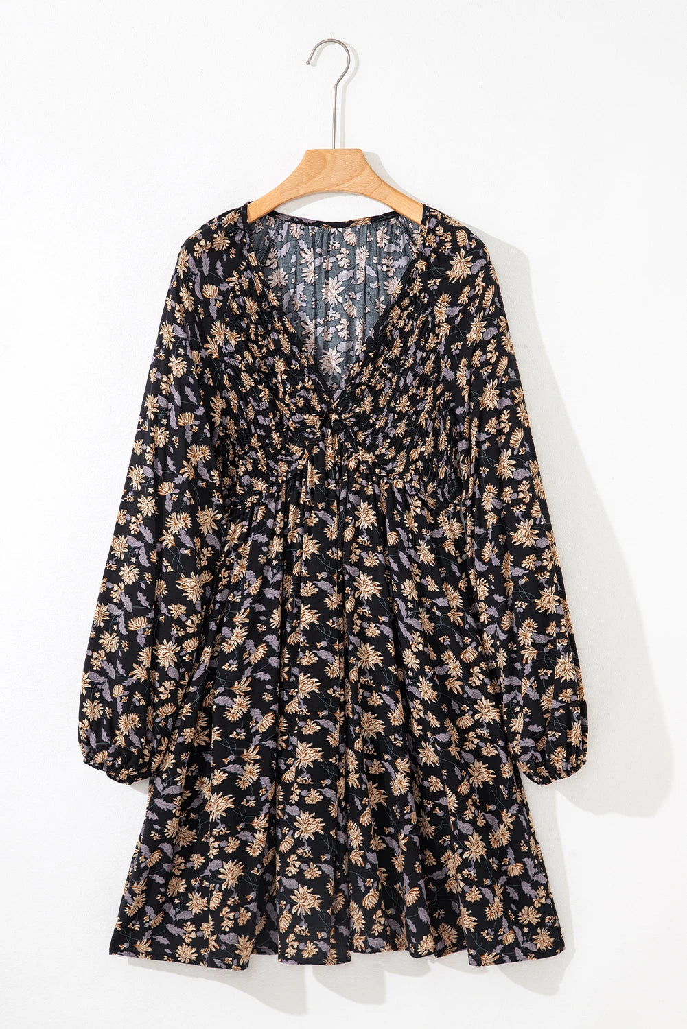 Floral dress on a hanger against a white background