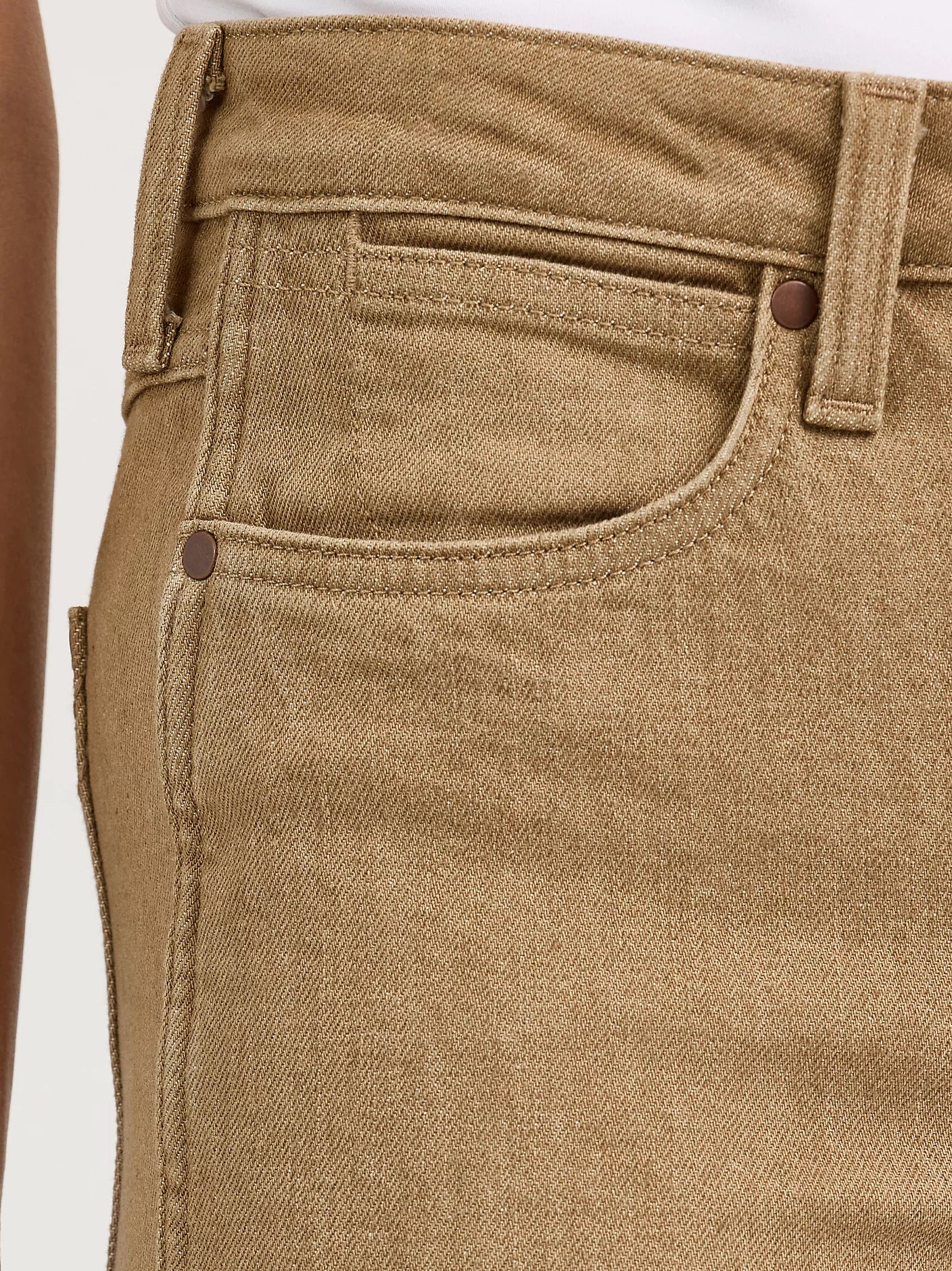Close-up of beige pants with a plain background