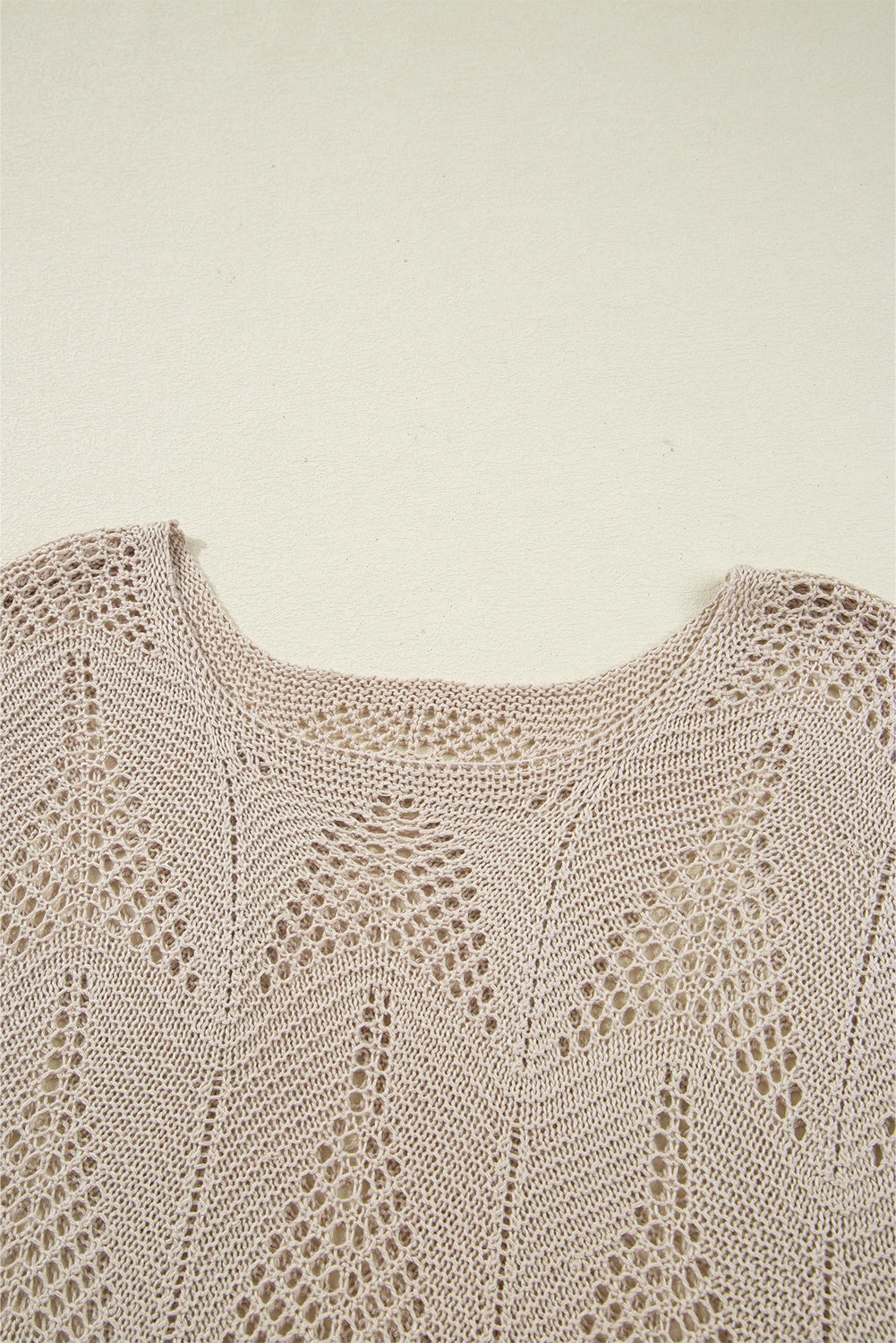 Close-up of a beige knitted garment on a light beige background