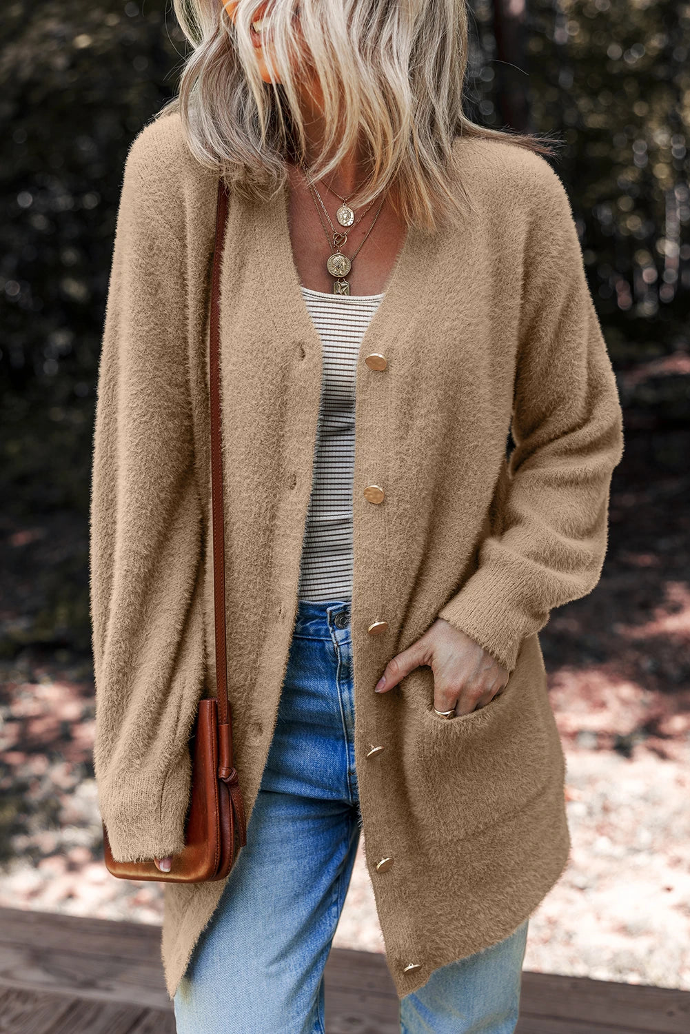 Person wearing a beige cardigan with a blurred background