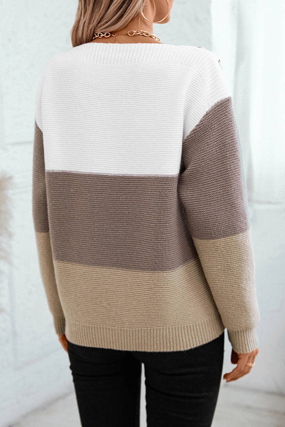 Person wearing a two-tone sweater with white and brown stripes against a white background