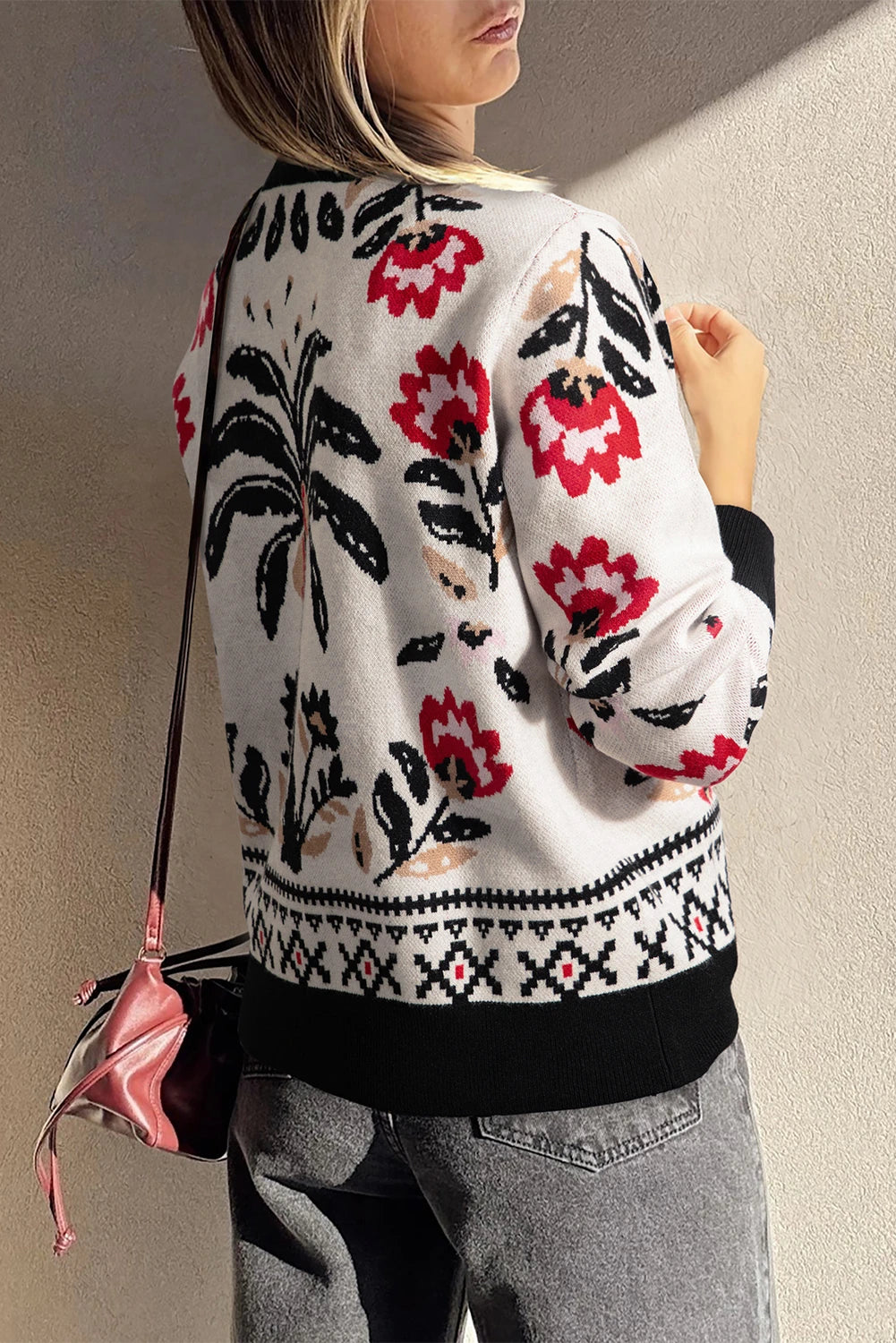 Person wearing a floral-patterned sweater with a plain background