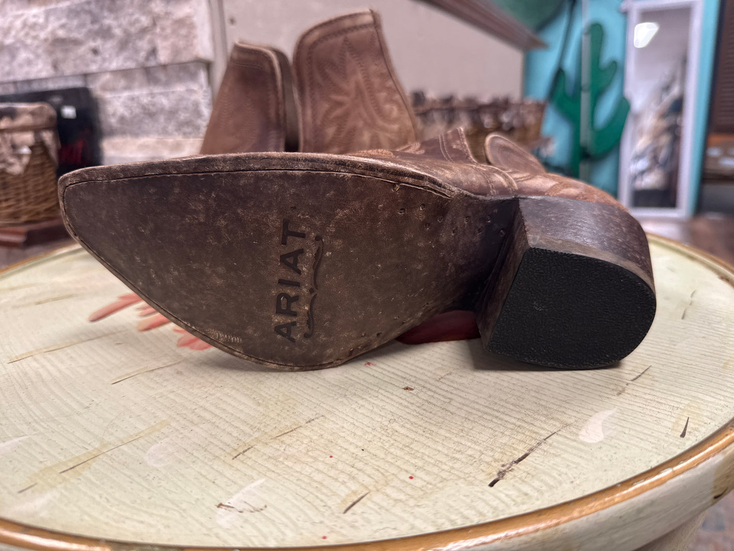 Close-up of Ariat boots on a round surface with a blurred background