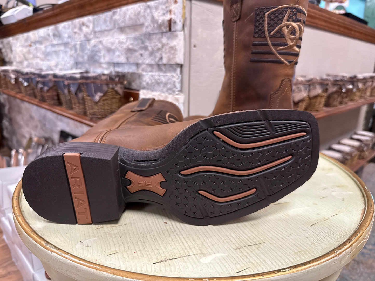 Brown boot with a visible brand logo on a white surface
