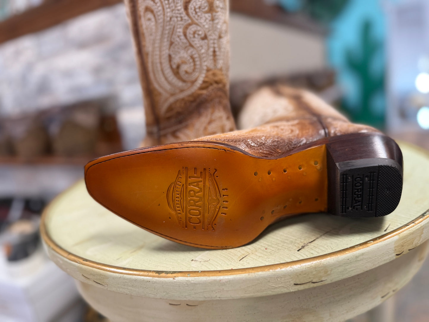 Close-up of a brown leather boot sole with 'Florran' branding on a wooden surface.