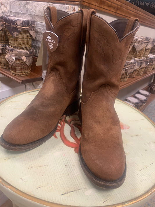 A pair of brown, distressed leather ARIAT men's western boots with a medium toe and pull-on style.