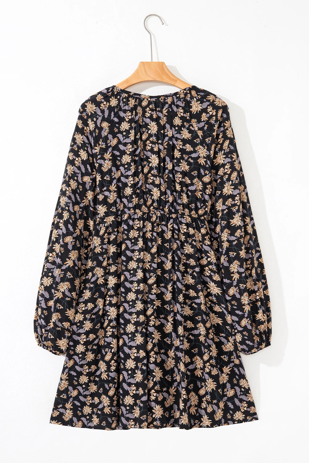 Floral dress on a hanger against a white background