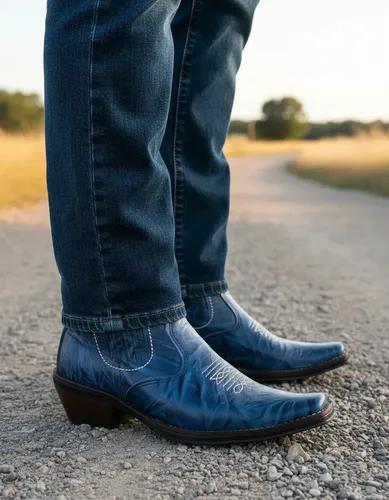 Men’s leather cowboy boots on a rustic wooden porch