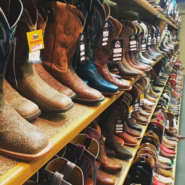 a shelf of western boots for sale