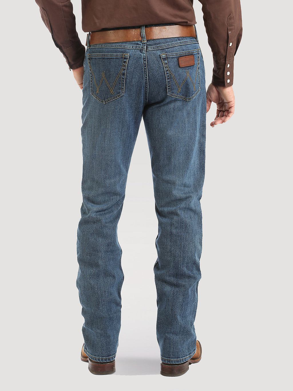 Person wearing blue jeans and a brown shirt on a white background