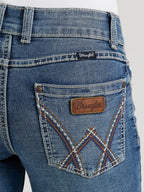 Close-up of blue denim jeans with a brand label on a white background