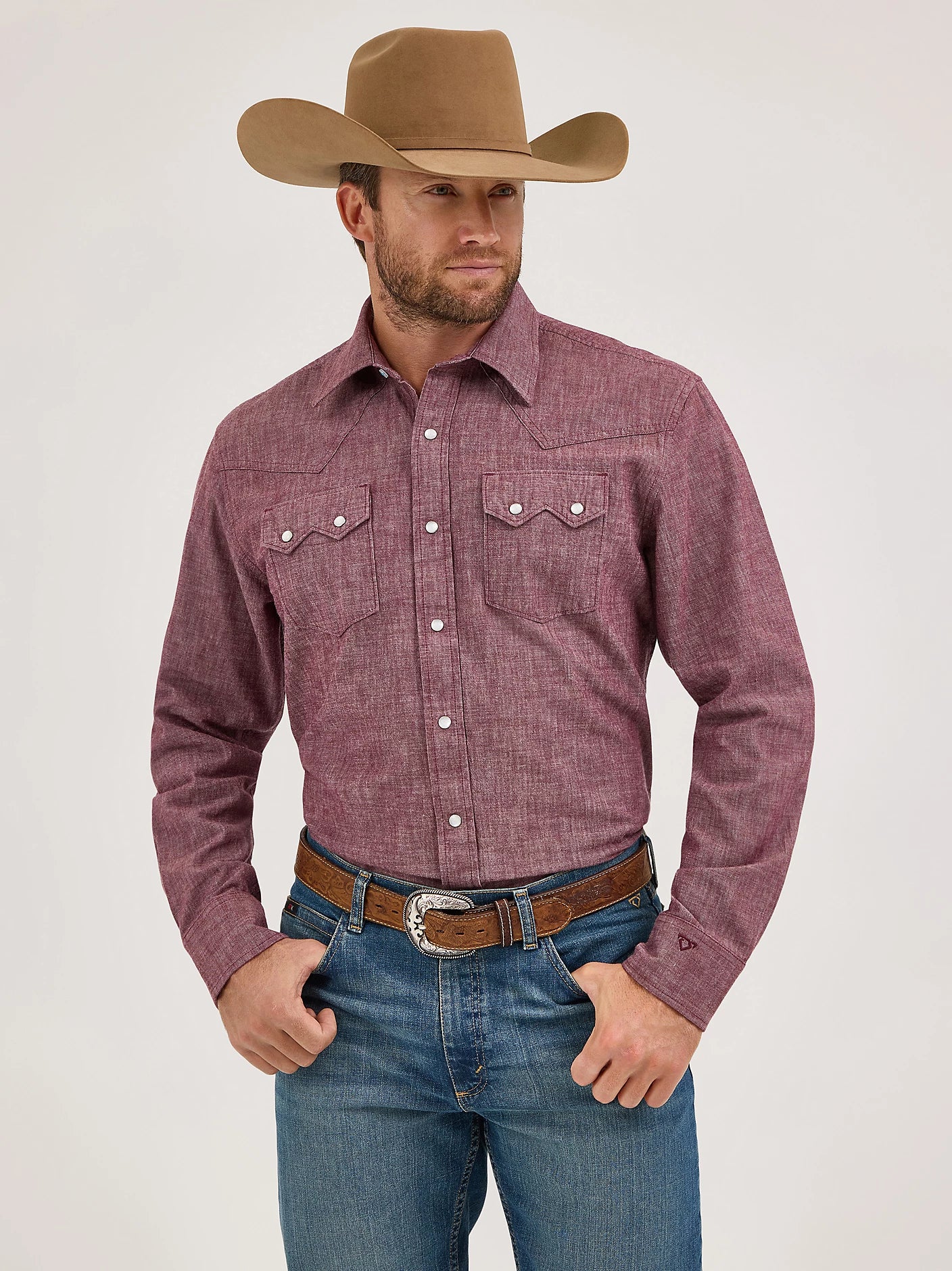 Man wearing a red plaid shirt, blue jeans, and a brown cowboy hat on a white background