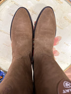 Brown suede shoes on a textured surface