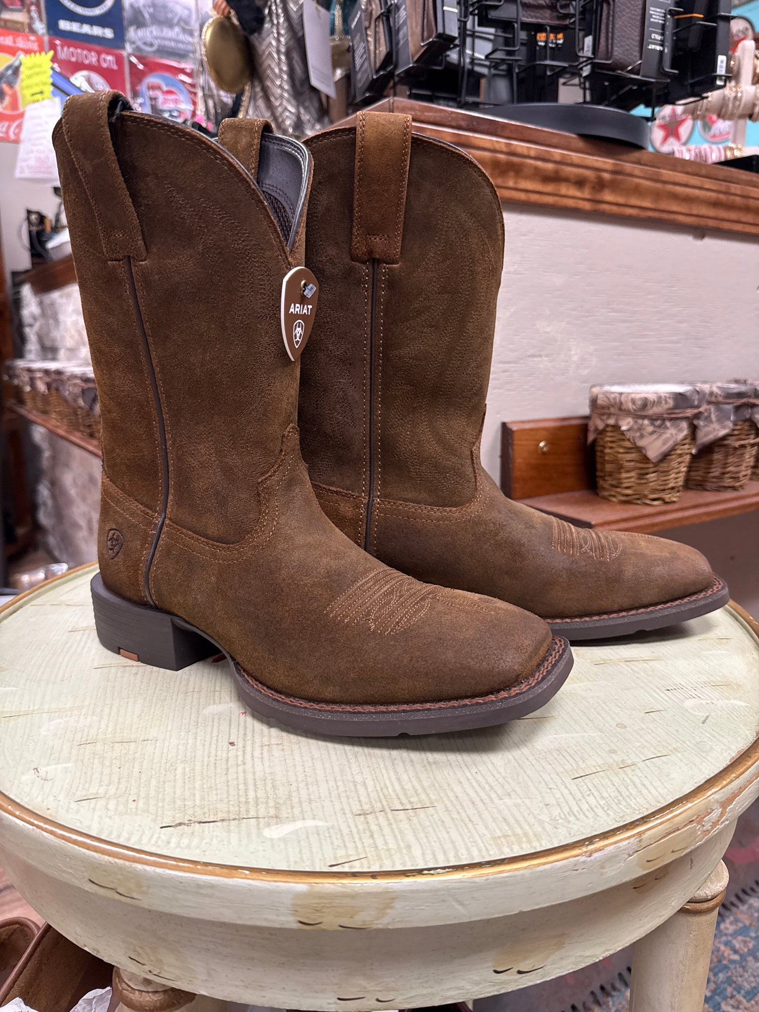 Brown suede boots on a round surface with a blurred background