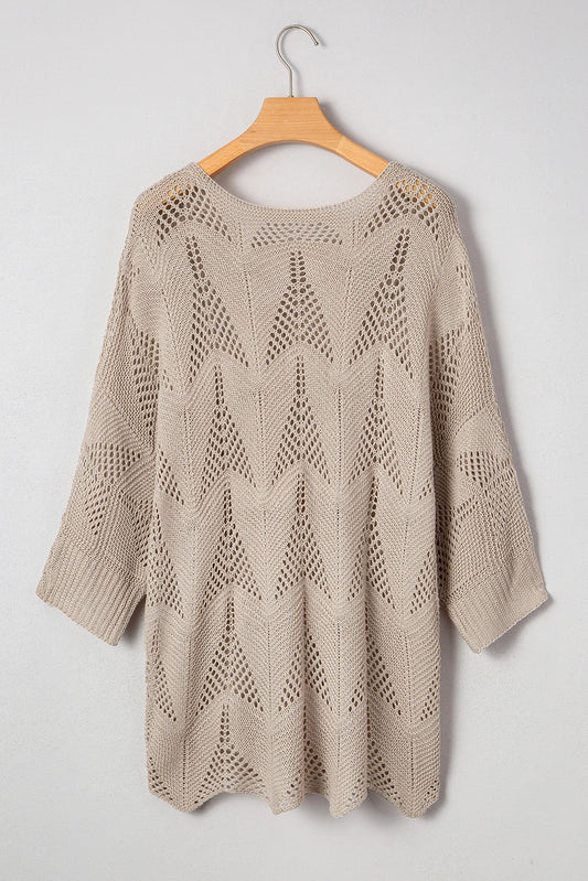 Beige knitted sweater on a wooden hanger against a white background