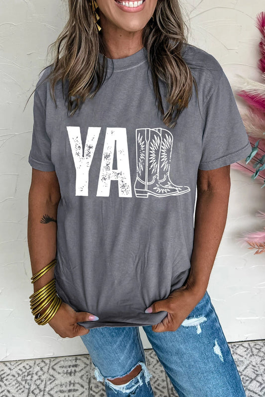Person wearing a gray t-shirt with a graphic design and jeans indoors.