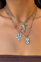 Necklace with bull head and cactus pendant on a person's neck