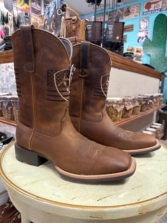 Brown leather boots with a decorative buckle on a wooden barrel in a store setting.