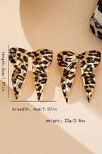 Leopard print butterfly-shaped earrings with measurements on a beige background