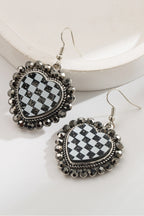 Heart-shaped earrings with checkered design and decorative elements on a white background