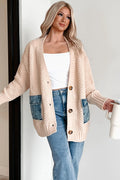 Woman wearing a beige cardigan with denim pockets, holding a white mug.