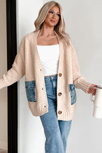Woman wearing a beige cardigan with denim pockets, holding a white mug.