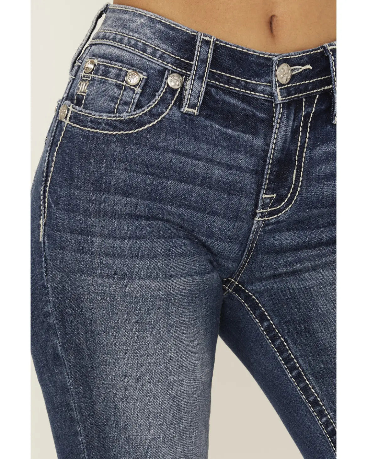 Close-up of blue jeans with a beige background