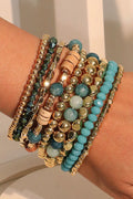 Stack of colorful beaded bracelets on a wrist against a neutral background