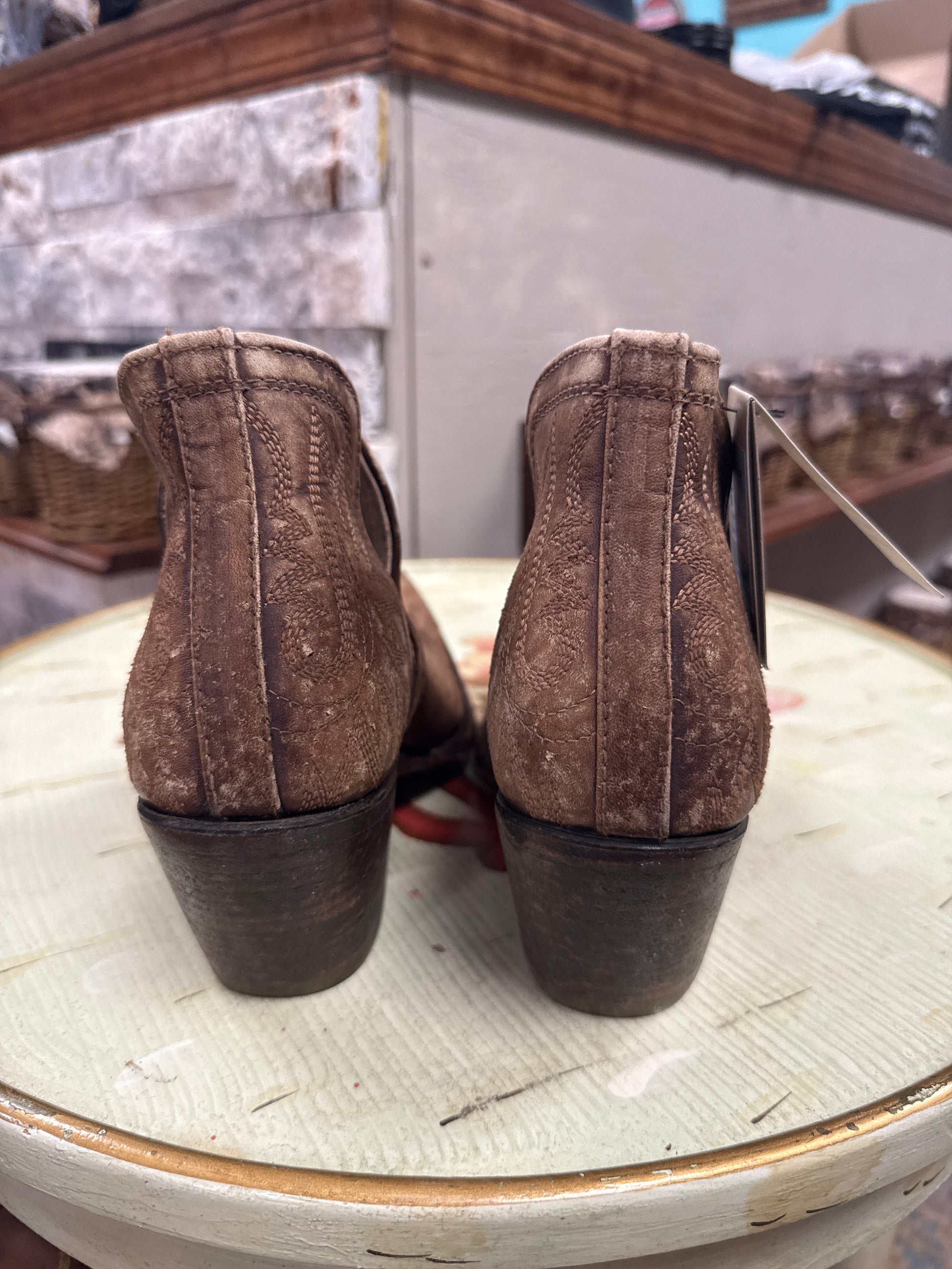 Pair of brown leather shoes on a white surface with a blurred background