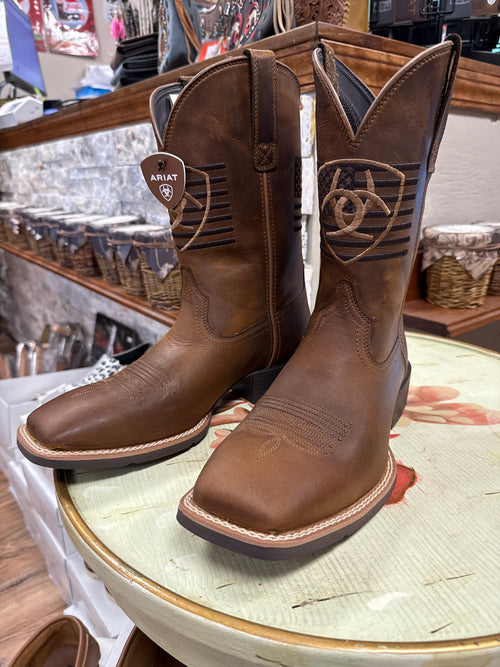 Brown leather boots with Ariat logo on a round surface
