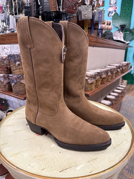 Brown suede boots on a wooden block with a store interior in the background