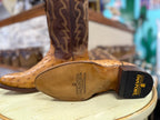 Brown cowboy boot with visible Dan Post logo on a wooden stool.