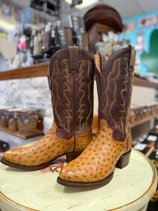 Brown and tan cowboy boot on a round white surface with a blurred store background