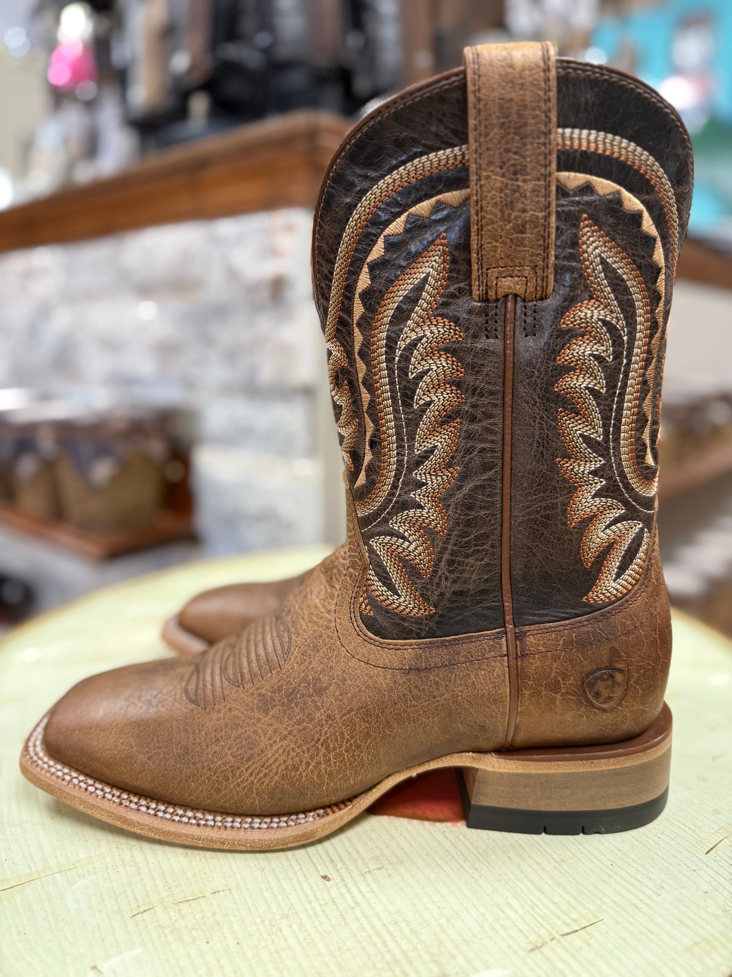 Brown cowboy boot with intricate leatherwork on a blurred background