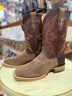 Pair of brown and tan cowboy boots with intricate designs on a round surface.