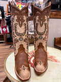Pair of brown cowboy boots with intricate designs on a round table.