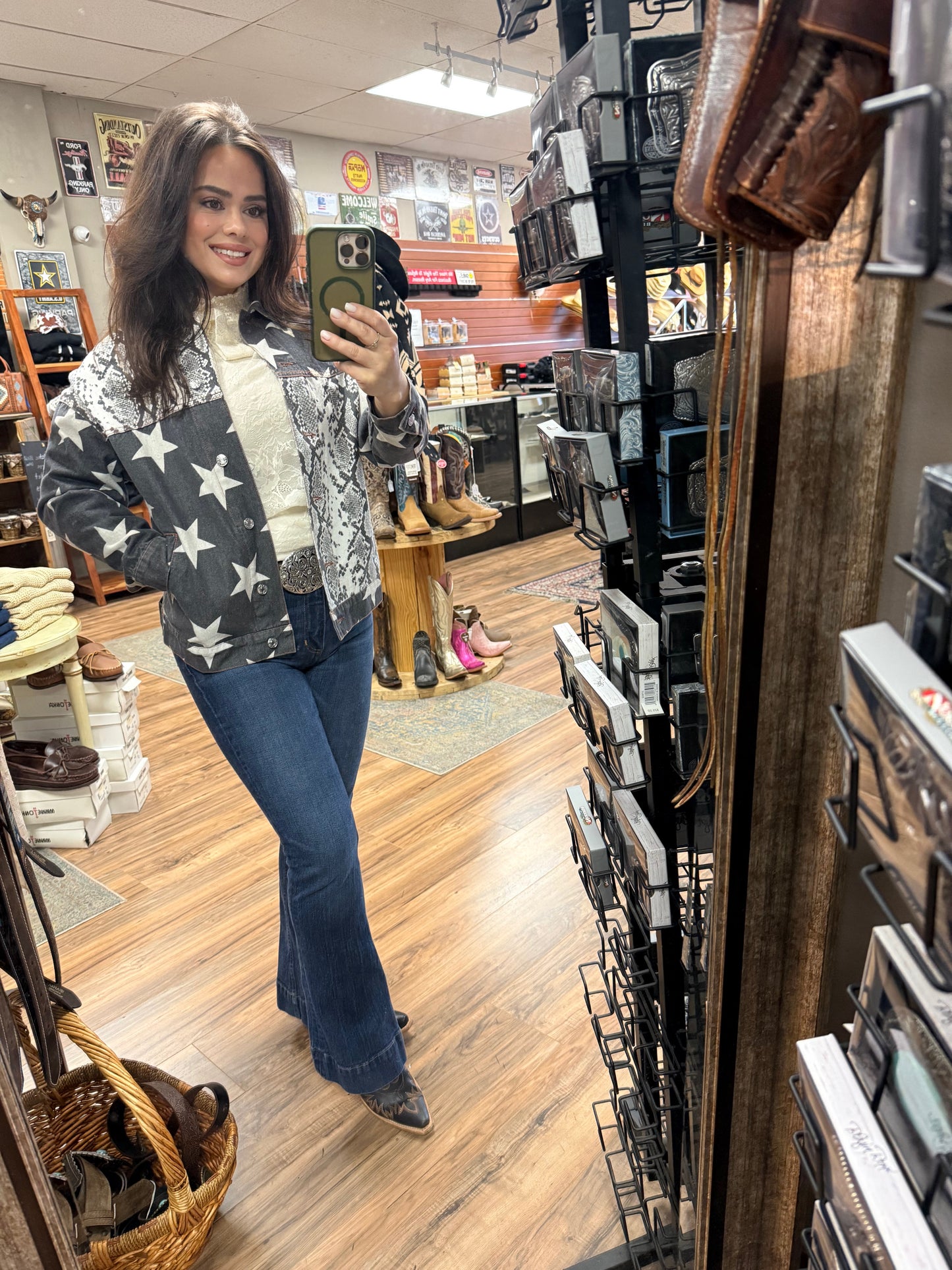 Woman taking a selfie in a store wearing an American flag sweater.