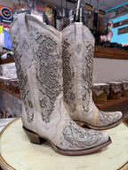 Pair of ornate cowboy boots on a table in a store setting
