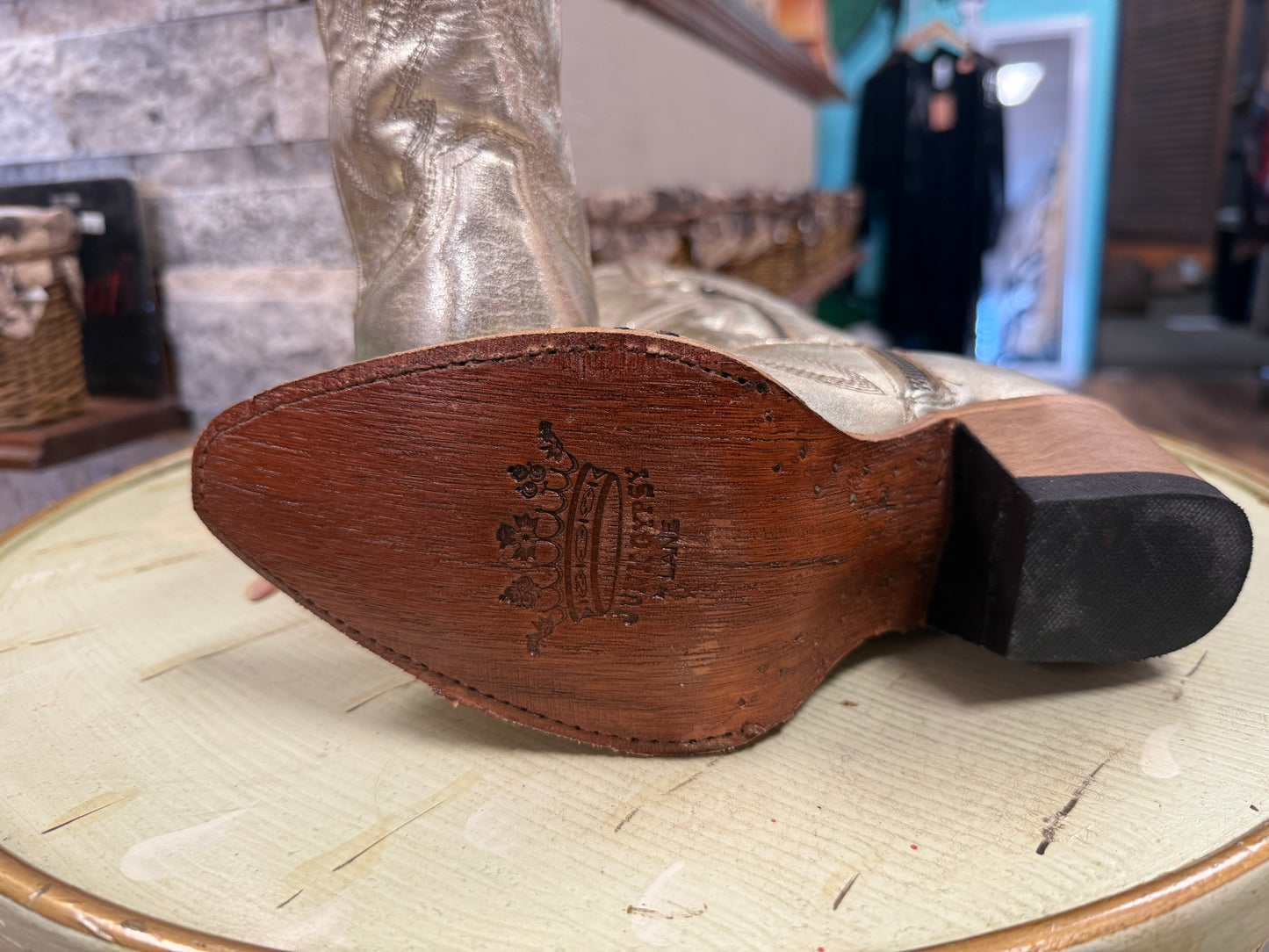 Wooden shoe last on a table with a blurred background of a store interior.