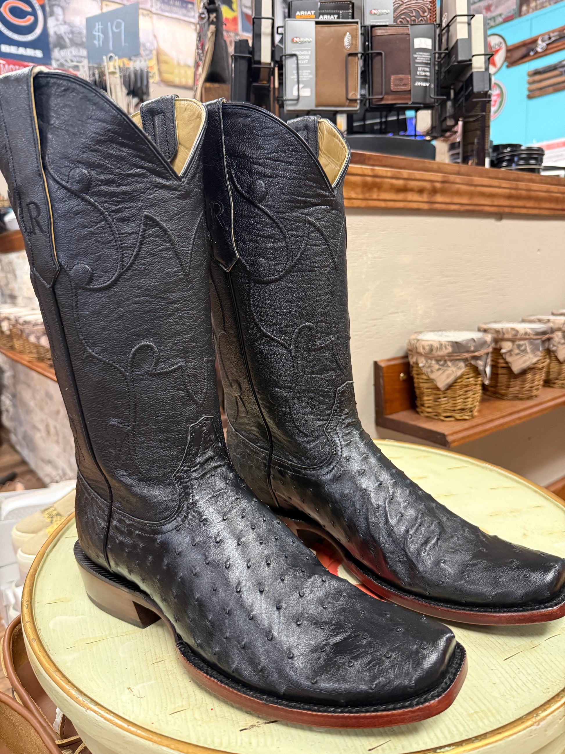 Pair of black cowboy boots on display in a store setting