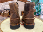 Pair of brown leather boots on a wooden surface with a blurred background