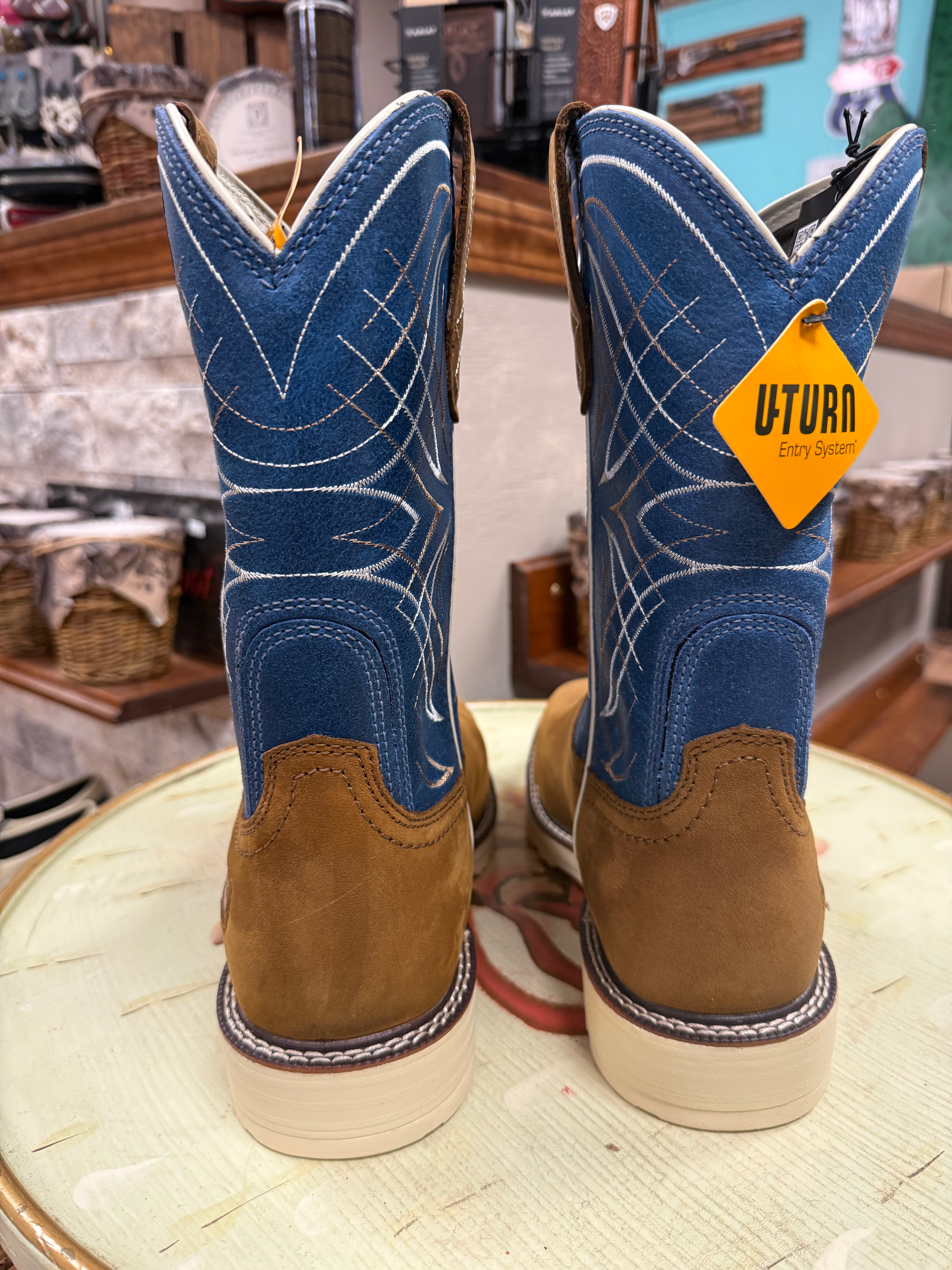 Blue and brown cowboy boots with a 'UTurn' tag on a wooden stool.