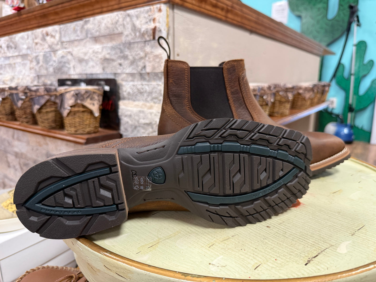 Brown boot with a focus on the sole in a store setting