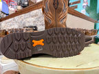 Close-up of a brown boot sole with an orange logo on a light green surface.