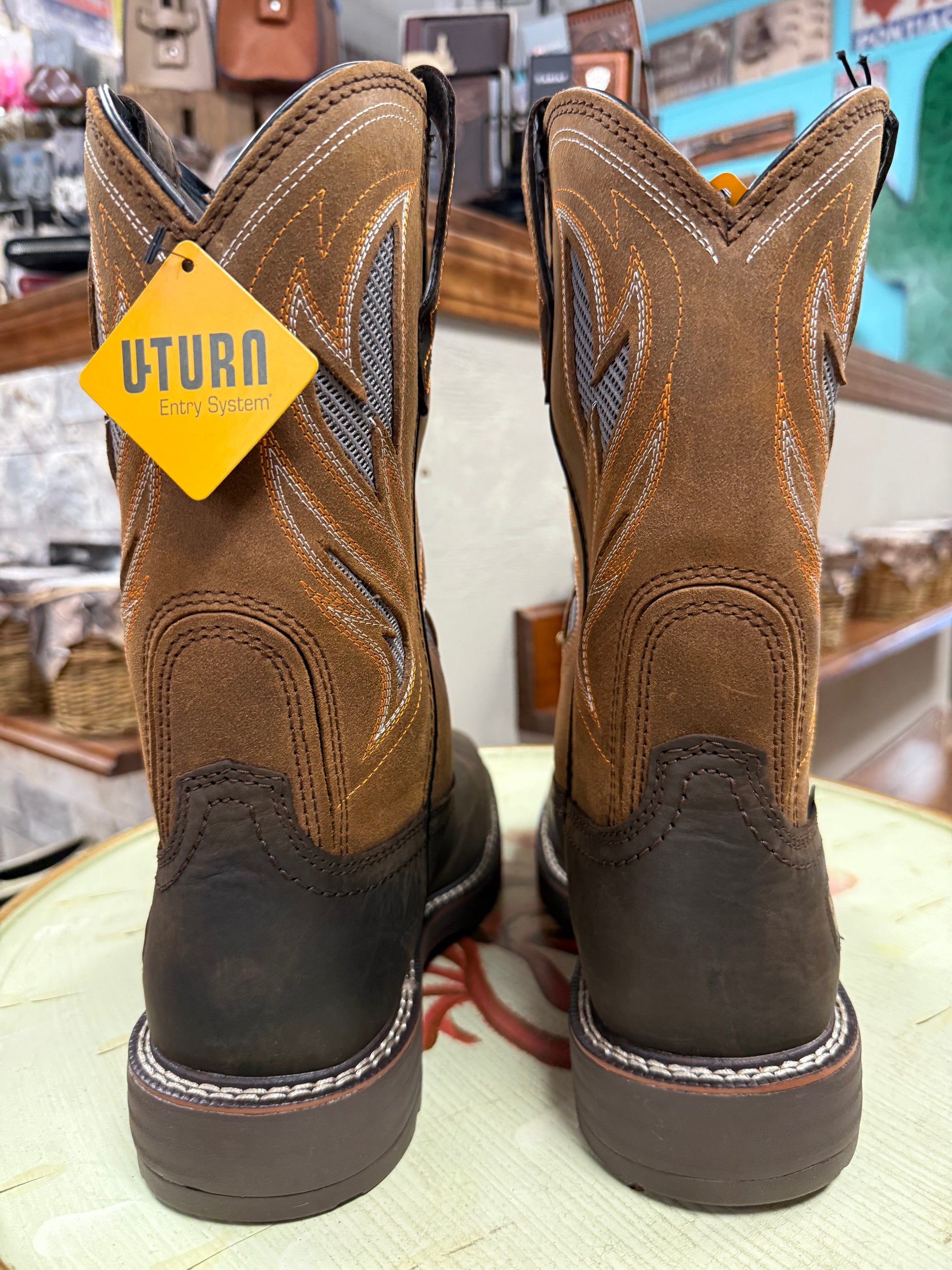 Pair of brown work boots with a UTurn tag on a light surface.