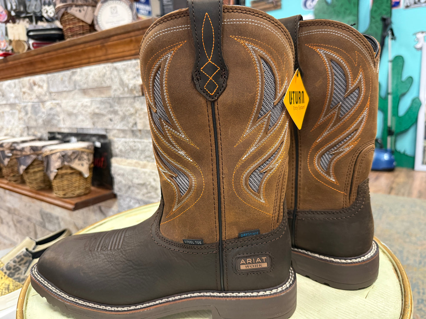Pair of brown Ariat boots on a stool with a store interior background