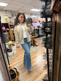 Woman taking a mirror selfie in a store with various items on display.