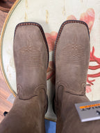 Brown leather boots with intricate stitching on a colorful background