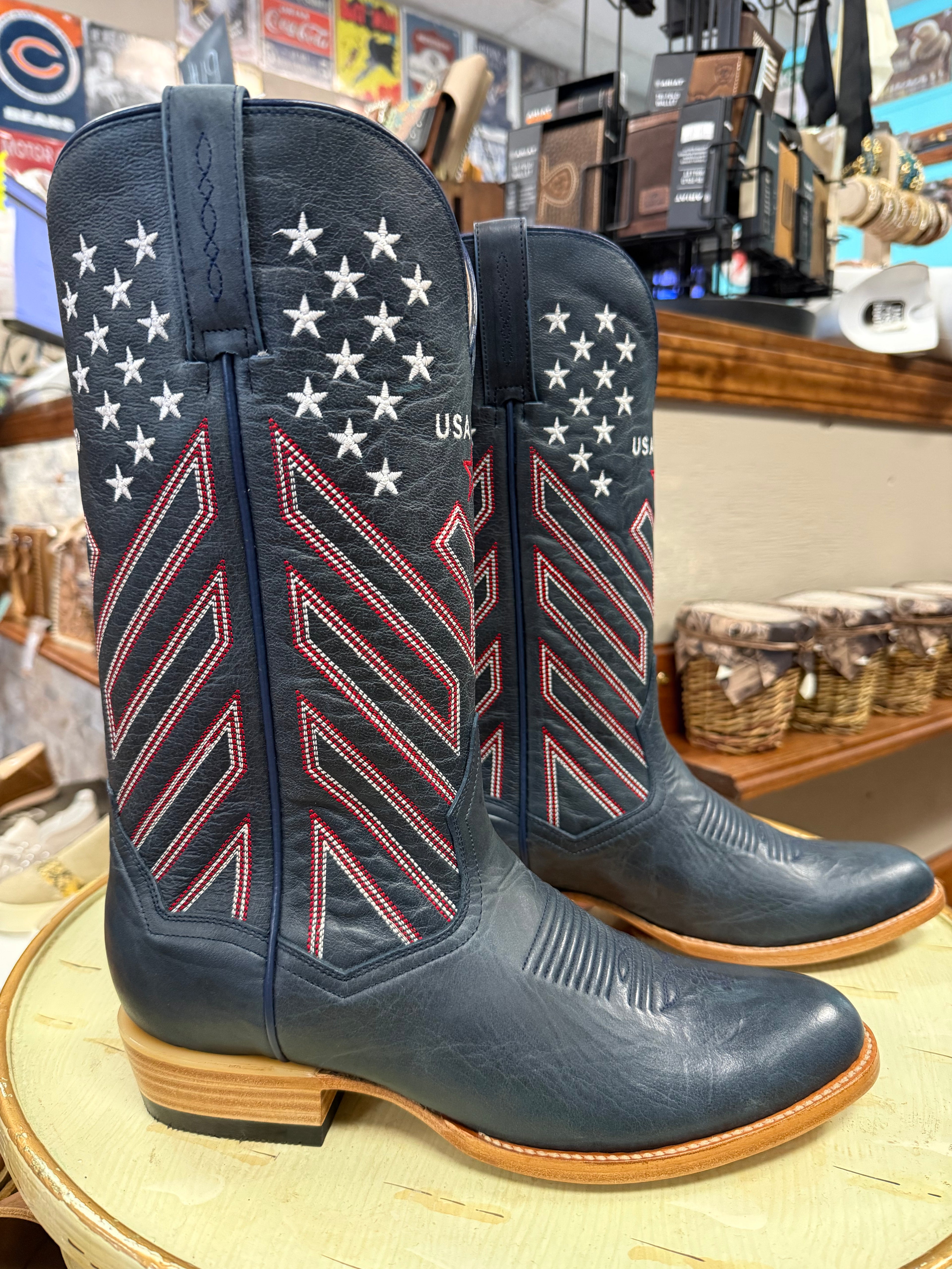 Blue cowboy boots with American flag design on a wooden surface.