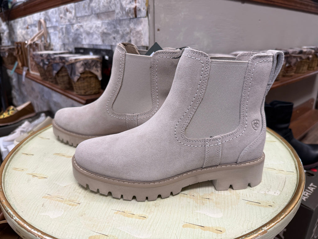 Pair of gray boots on a round surface with a blurred background
